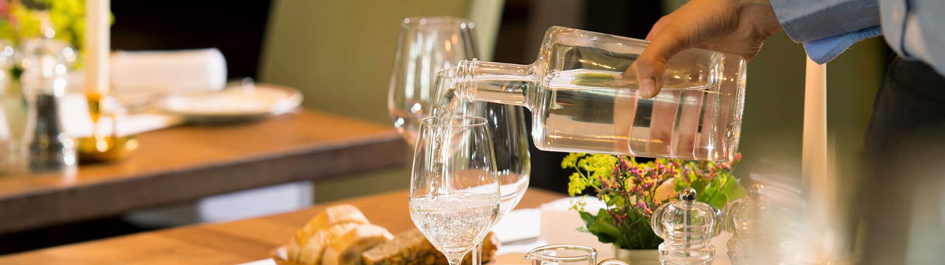 Wasser ausschenken aus Karaffe im Restaurant