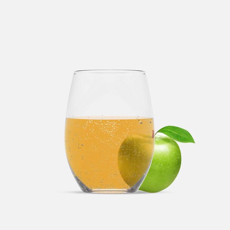 befülltes Wasserglas mit Apfelwasser. Neben dem Glas liegt ein Apfel.
