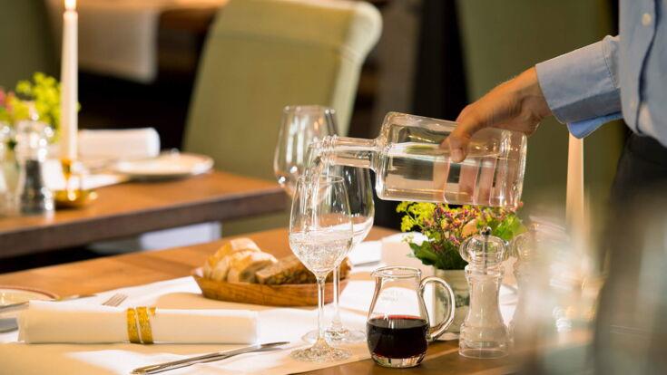 Wasser ausschenken aus Karaffe im Restaurant