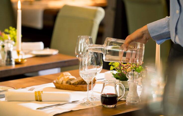 Wasser ausschenken aus Karaffe im Restaurant