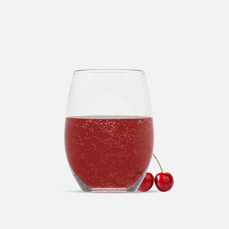 Glas mit Kirschwasser und daneben eine platzierte Kirsche